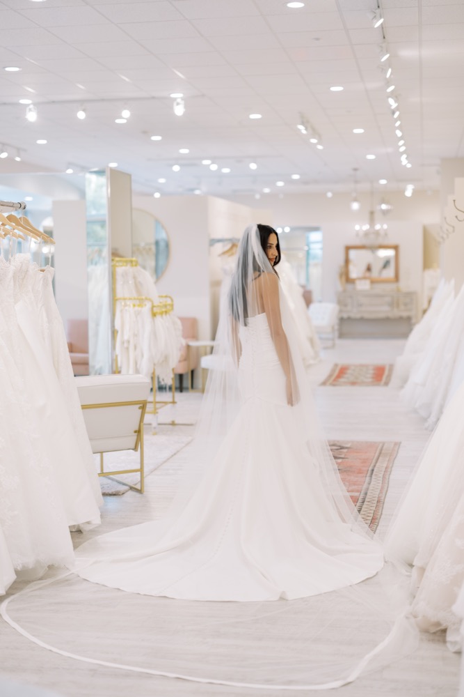 Two brides trying on wedding gowns together in the showroom