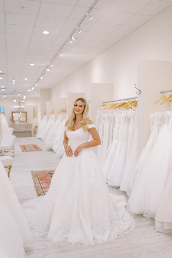 Bride in a dramatic ballgown beneath a crystal chandelier at Brickhouse Bridal