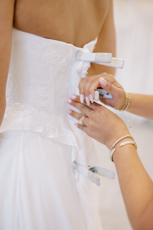 Close-up of a wedding gown being buttoned