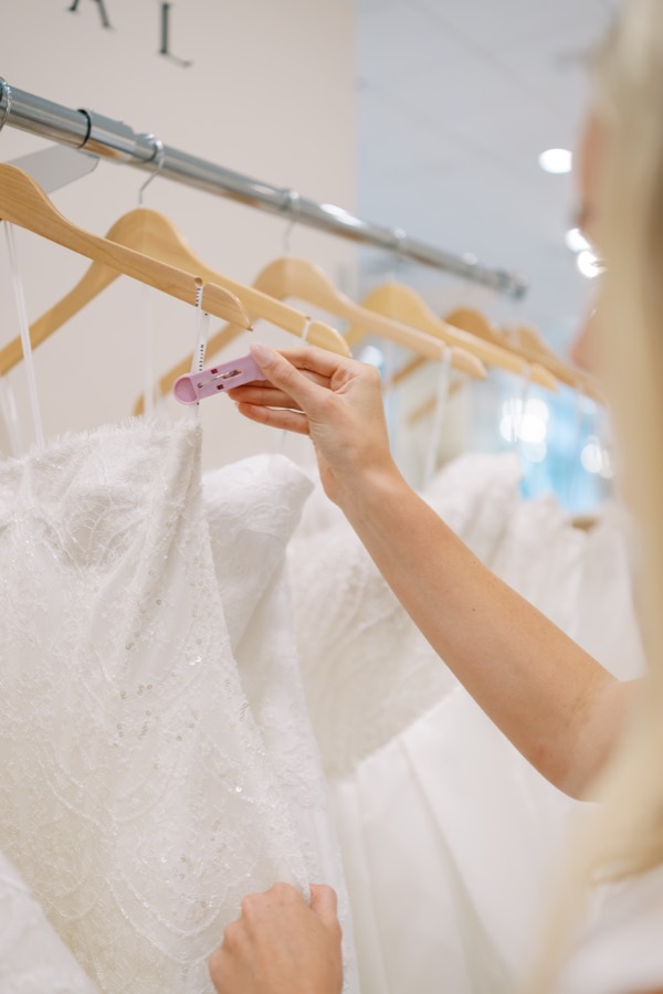 Bride browsing wedding gowns on a rack