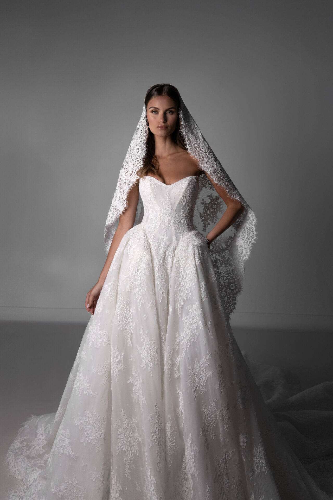 Bride in a Martina Liana Luxe strapless lace ballgown wearing a lace cathedral veil