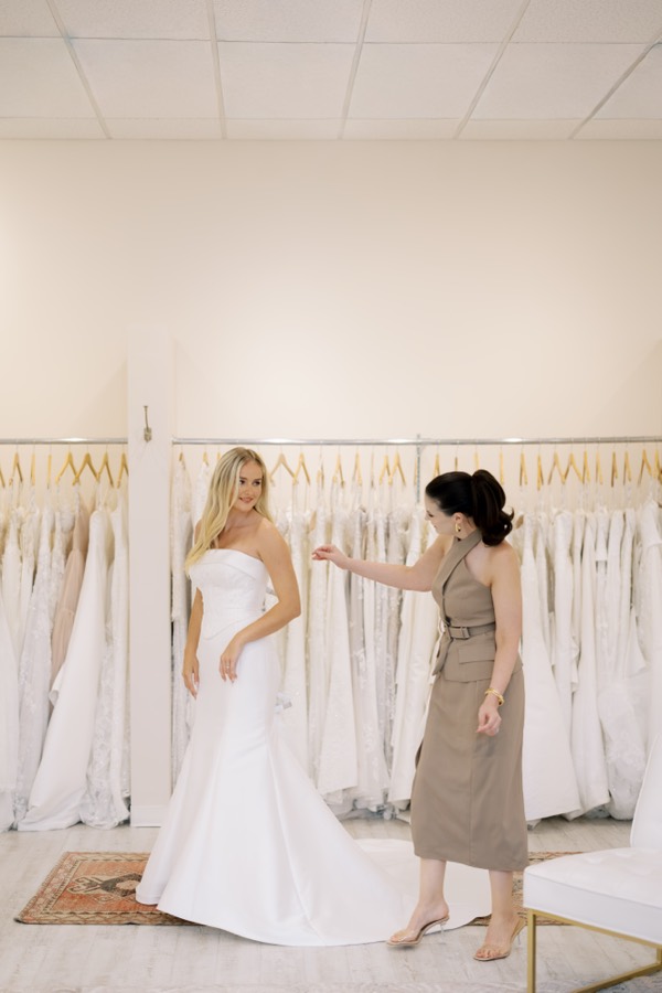 Bride looking through wedding gowns on the rack at Brickhouse Bridal